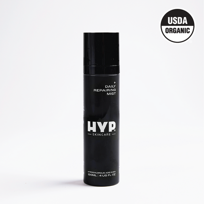 A standalone image of a black bottle of 'HYP Daily Repairing Mist' set against a plain white background. The product is labeled with the brand name 'HYP' in large white letters and the words 'Daily Repairing Mist' above it. The 'USDA ORGANIC' seal is visible in the upper right corner of the bottle, certifying its organic status.