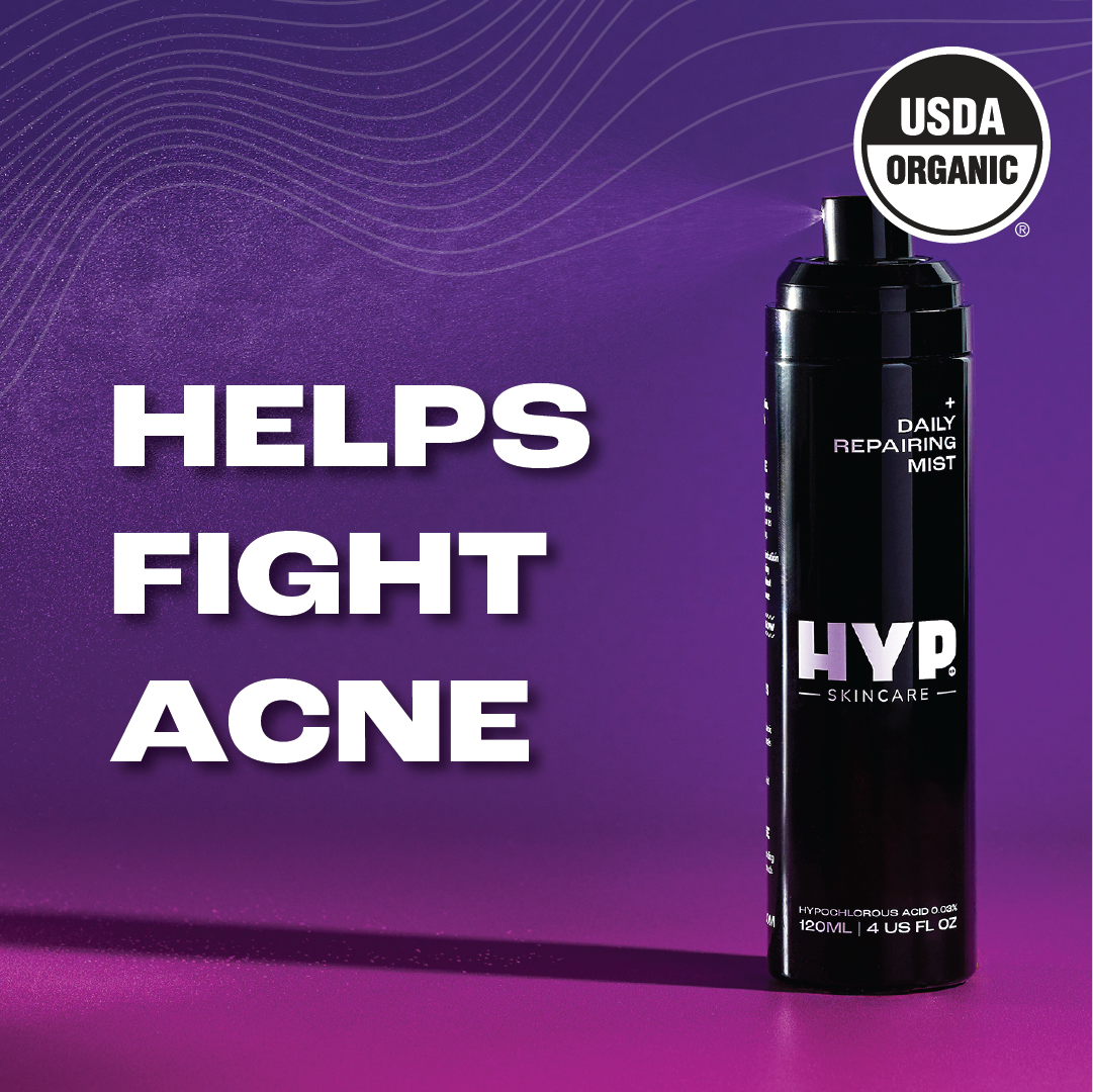 Promotional graphic featuring a black bottle of skincare spray labeled 'HYP Daily Repairing Mist' against a vibrant pink to dark purple gradient background. Bold white text states 'HELPS FIGHT ACNE' along with a 'USDA ORGANIC' seal in the upper left corner, suggesting the product is certified organic and intended for acne treatment.