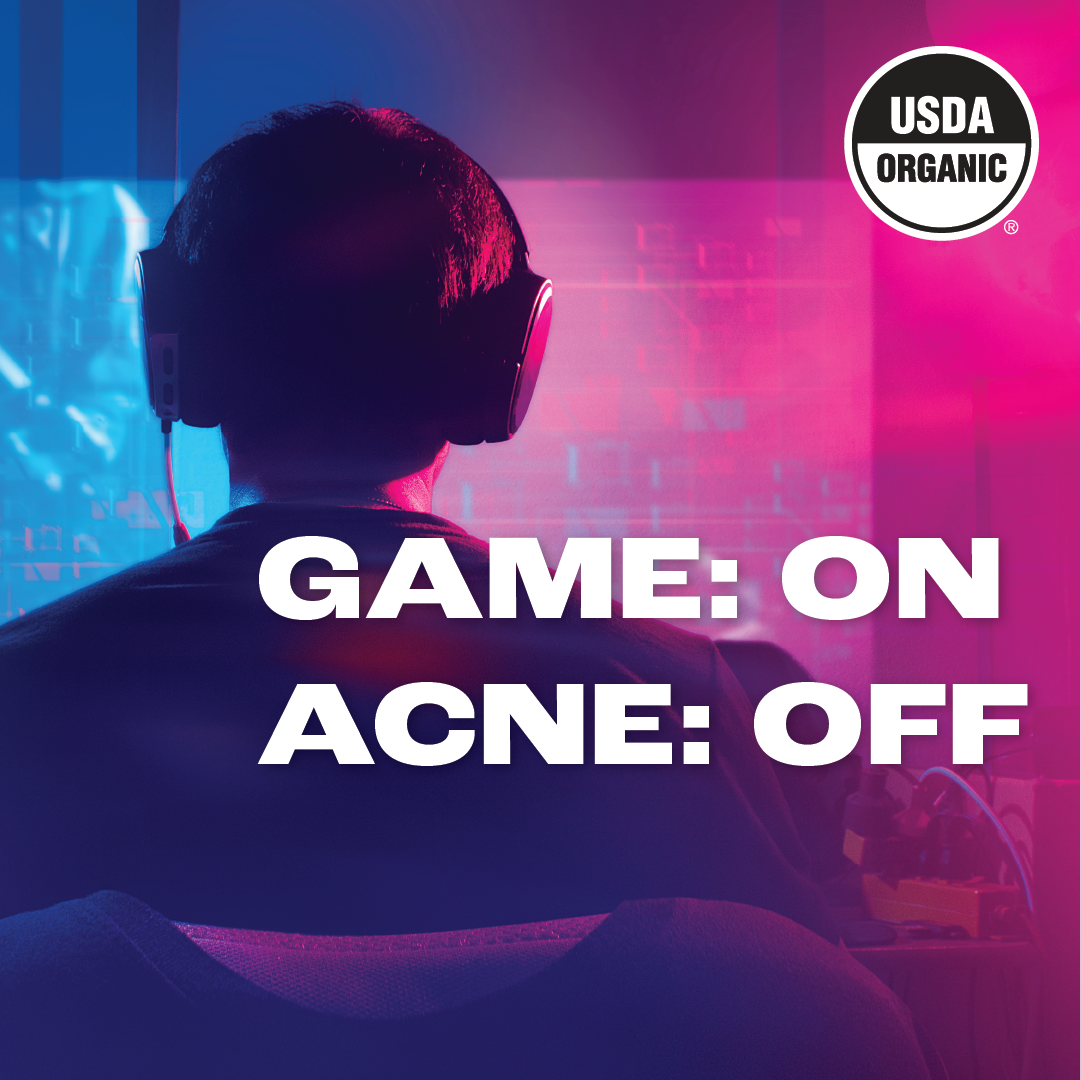 Image of a silhouette of a person wearing gaming headphones, sitting in front of a computer with a vivid blue and pink backlighting, suggesting a gaming environment. Bold white text in the foreground reads 'GAME: ON ACNE: OFF,' symbolizing the effectiveness of HYP Daily Repairing Mist for gamers. The 'USDA ORGANIC' seal is in the upper right corner, implying the product's organic certification.
